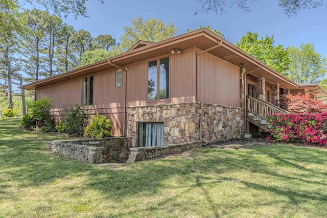 view of property exterior with a yard and stone siding