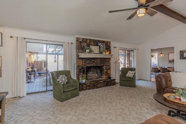 carpeted living room featuring vaulted ceiling with beams, a ceiling fan, a stone fireplace, and a wealth of natural light