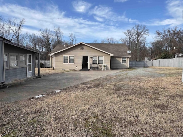 back of property with a yard, fence, driveway, and a patio