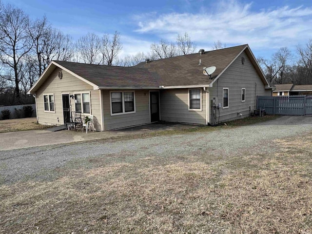 back of property with cooling unit, gravel driveway, a patio area, and fence