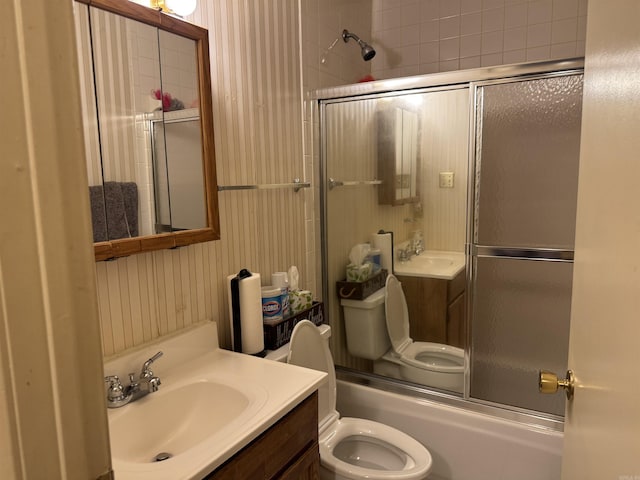 full bathroom featuring vanity, toilet, and bath / shower combo with glass door