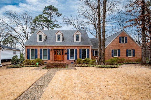 cape cod home with roof with shingles, brick siding, and crawl space