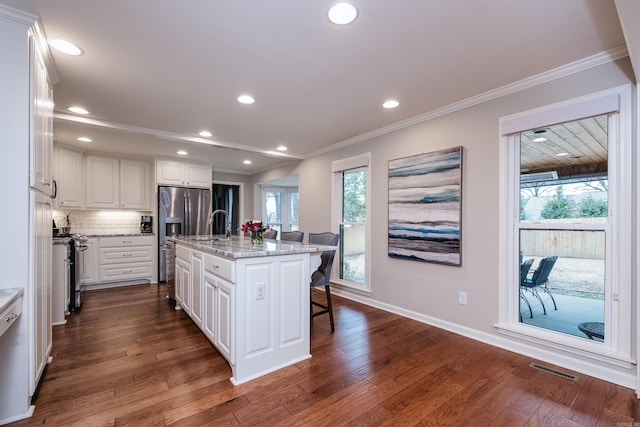 kitchen featuring stainless steel appliances, dark wood finished floors, white cabinetry, and crown molding