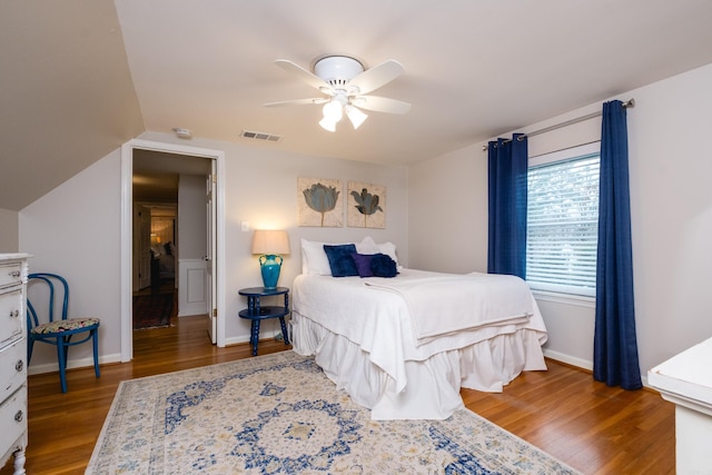 bedroom with a ceiling fan, baseboards, visible vents, and wood finished floors