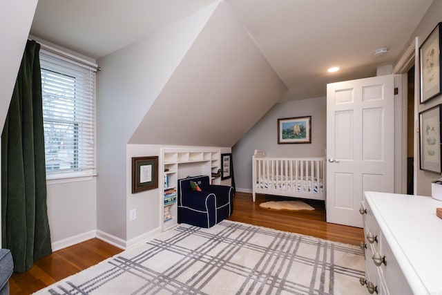 bedroom with lofted ceiling, wood finished floors, and baseboards