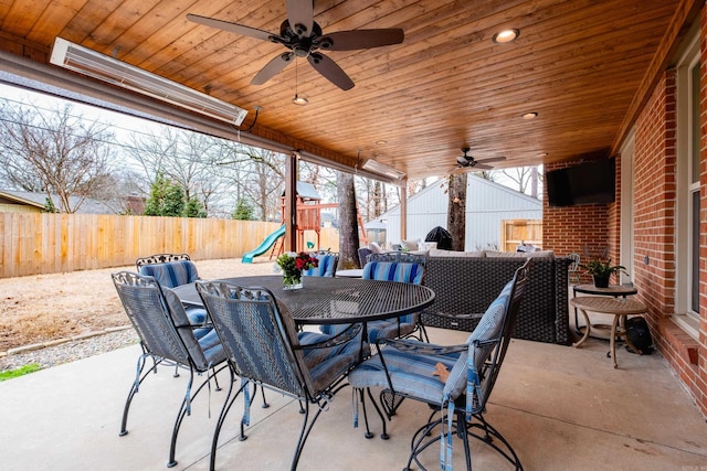 view of patio / terrace with a ceiling fan, outdoor dining area, a fenced backyard, and a playground