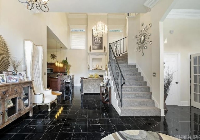 entryway with a towering ceiling, stairs, a chandelier, and crown molding