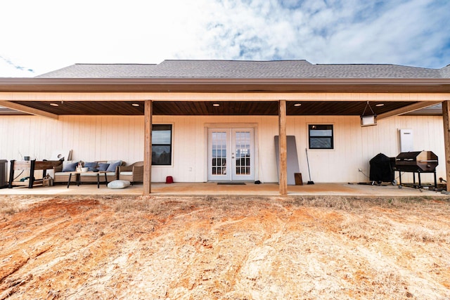 back of house featuring a shingled roof, a patio area, and outdoor lounge area