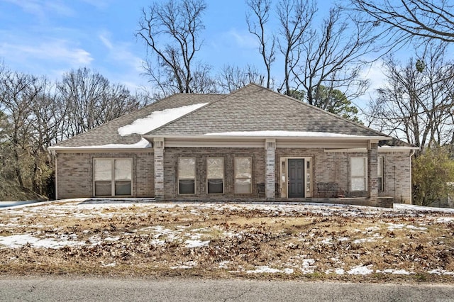 exterior space with a shingled roof and brick siding