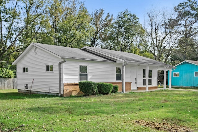 rear view of house featuring a lawn and brick siding