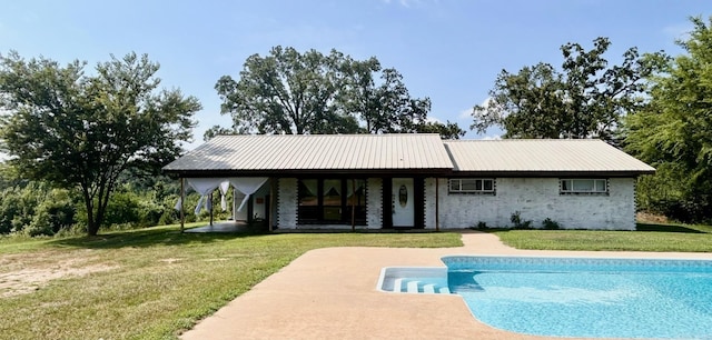 outdoor pool featuring a yard