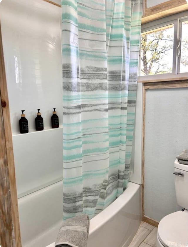 full bathroom featuring toilet, shower / bathtub combination with curtain, and baseboards