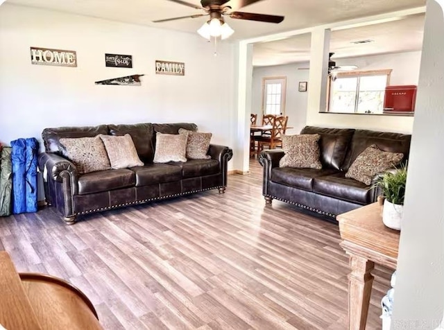 living area with wood finished floors and a ceiling fan