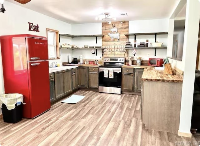 kitchen with stainless steel range with electric cooktop, wood counters, fridge, and open shelves