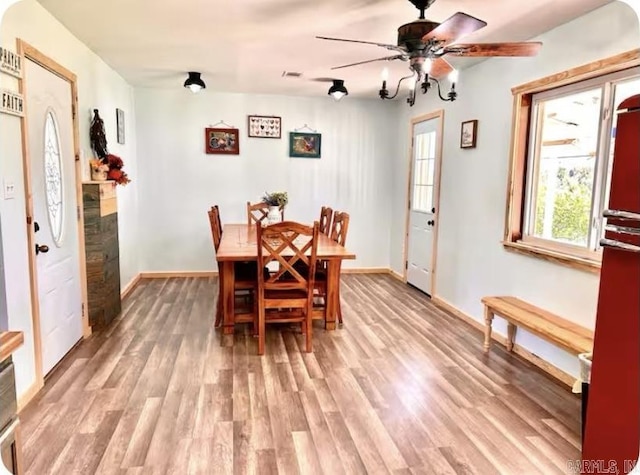 dining room with ceiling fan, wood finished floors, and baseboards