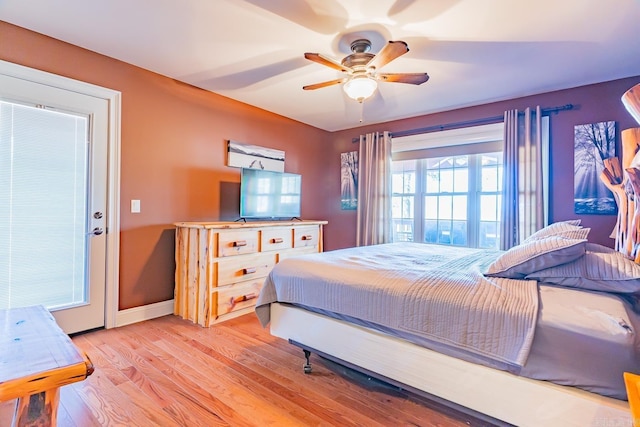 bedroom featuring a ceiling fan, light wood-style flooring, and baseboards