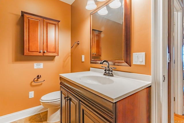 bathroom with baseboards, vanity, toilet, and tile patterned floors