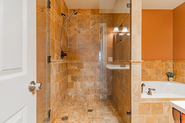 full bathroom with a shower stall and a bath