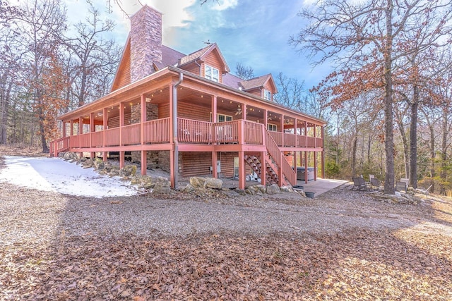 view of property exterior with stairs, a chimney, and a wooden deck