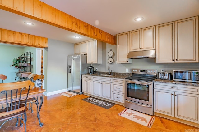 kitchen featuring stainless steel appliances, recessed lighting, a sink, dark stone counters, and under cabinet range hood