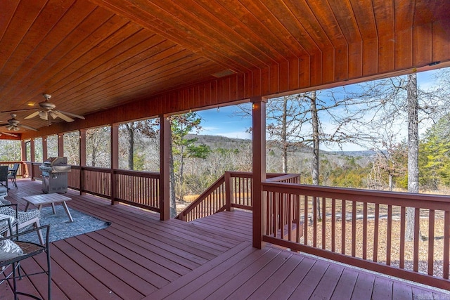 wooden deck with grilling area and a ceiling fan