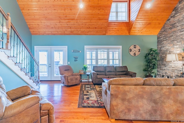 living room with light wood finished floors, plenty of natural light, stairs, and french doors