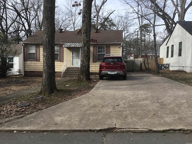 view of front of home featuring crawl space, fence, concrete driveway, a shingled roof, and entry steps