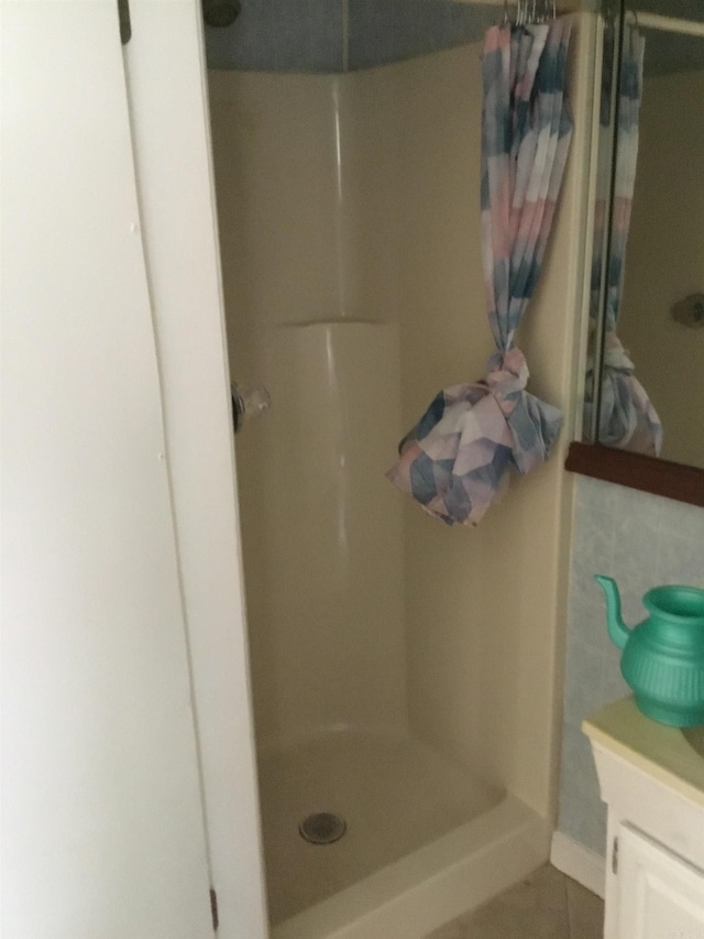 full bath with vanity, tile patterned floors, and a stall shower