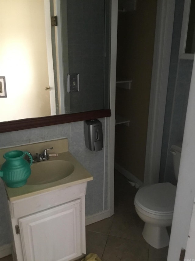half bathroom featuring vanity, tile patterned floors, and toilet