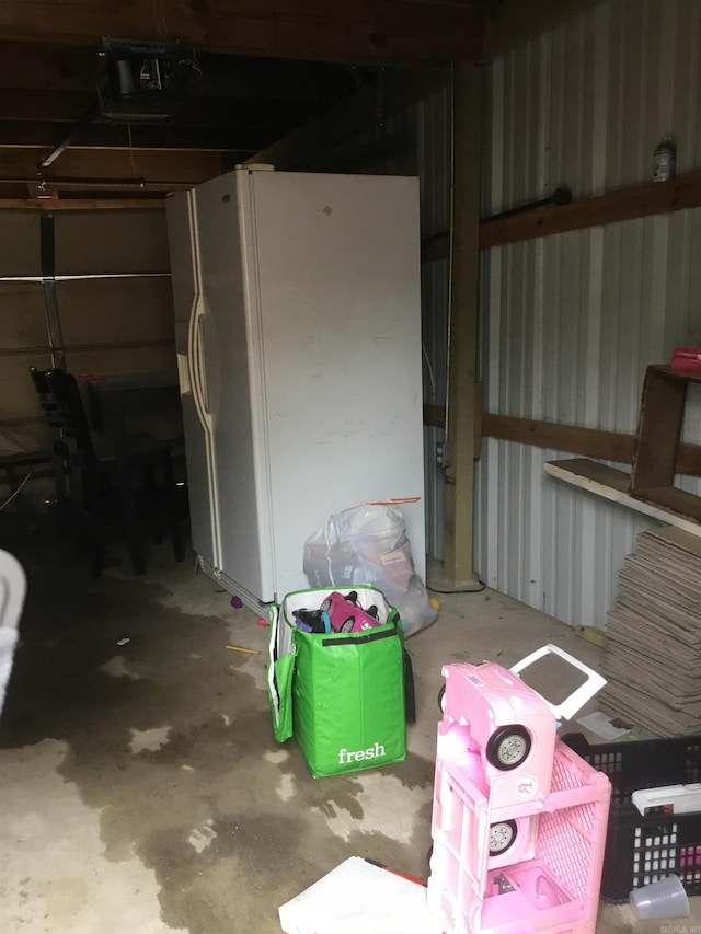 garage featuring a garage door opener and white fridge with ice dispenser