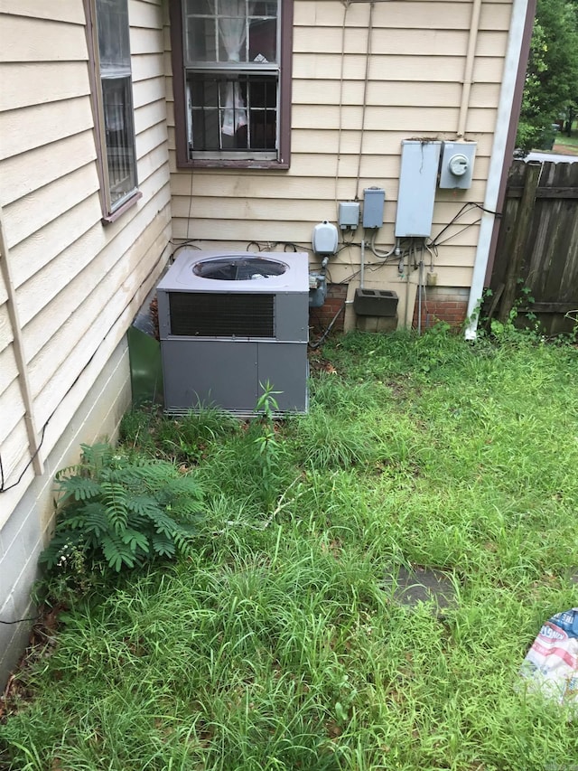 exterior details with central air condition unit, fence, and electric meter