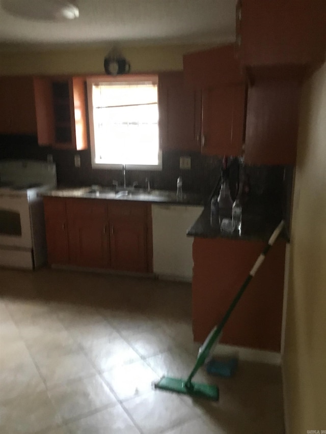 kitchen featuring a sink, brown cabinets, and electric range