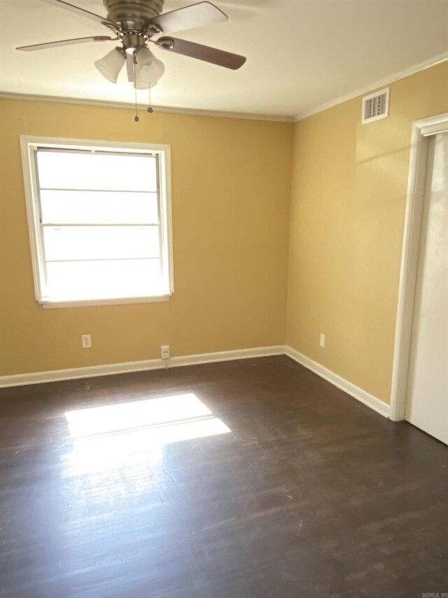 empty room featuring baseboards, visible vents, ceiling fan, and ornamental molding