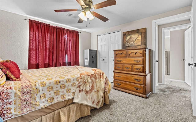 bedroom with a closet, light colored carpet, visible vents, ceiling fan, and baseboards