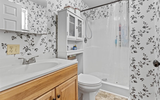 full bathroom with a stall shower, vanity, toilet, and wallpapered walls