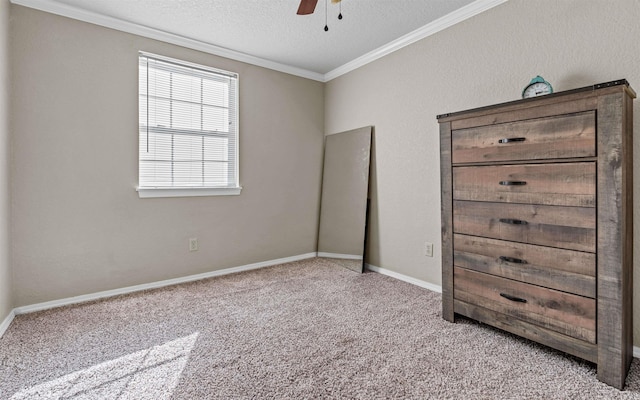 unfurnished bedroom with light carpet, baseboards, a ceiling fan, ornamental molding, and a textured ceiling