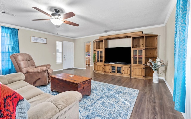 living area featuring ornamental molding, visible vents, a textured ceiling, and dark wood-type flooring