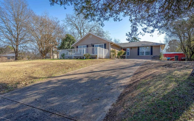 single story home with covered porch, a front lawn, and aphalt driveway