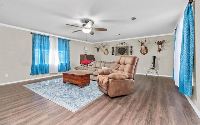 living area with dark wood-style flooring, visible vents, ornamental molding, a ceiling fan, and baseboards