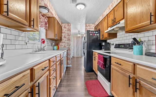 kitchen featuring white appliances, brown cabinets, light countertops, under cabinet range hood, and a sink