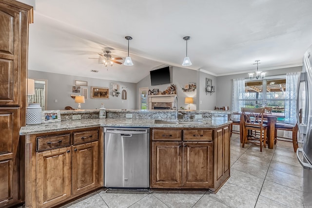 kitchen with brown cabinets, light stone countertops, stainless steel dishwasher, a fireplace, and a sink