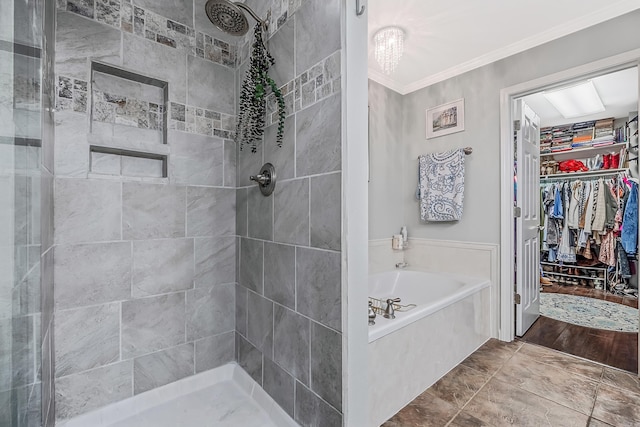 bathroom featuring a stall shower, a spacious closet, ornamental molding, and a bath