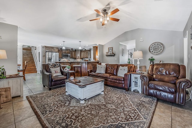 living area featuring lofted ceiling, ceiling fan, light tile patterned floors, and stairway