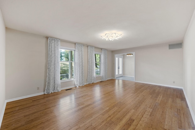 unfurnished room featuring light wood-style floors, baseboards, and visible vents