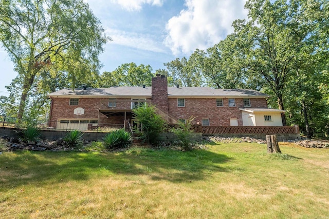 rear view of property featuring a yard, a chimney, and brick siding