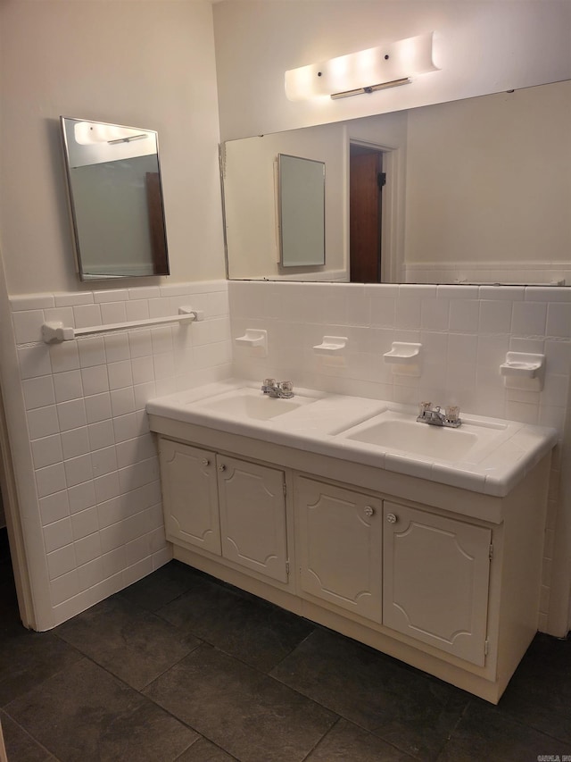 full bath featuring double vanity, a wainscoted wall, tile walls, and a sink