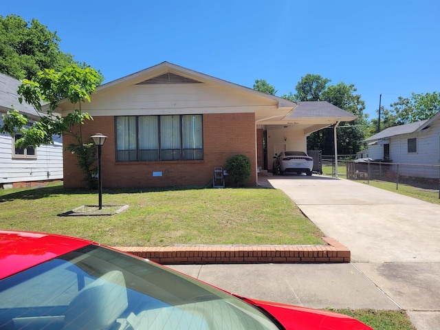 view of front of property with an attached carport, concrete driveway, brick siding, and a front yard