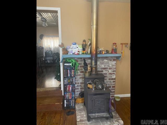 room details featuring a wood stove, baseboards, and wood finished floors