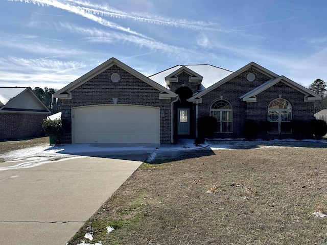 view of front of home featuring driveway, a garage, and brick siding