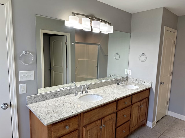 bathroom with double vanity, a stall shower, tile patterned flooring, and a sink